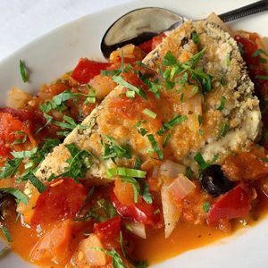 Fish fillet topped with tomatoes, peppers and fresh herbs