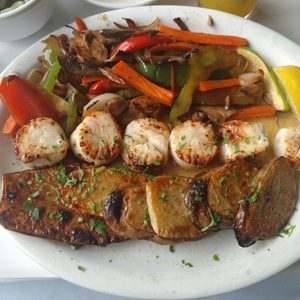 Grilled scallops and fish with sautéed peppers and vegetables